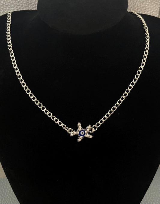 Silver Starfish Evil Eye Necklace adorned with protective symbols and intricate detailing, perfect for beach lovers and a stylish accessory for everyday wear.