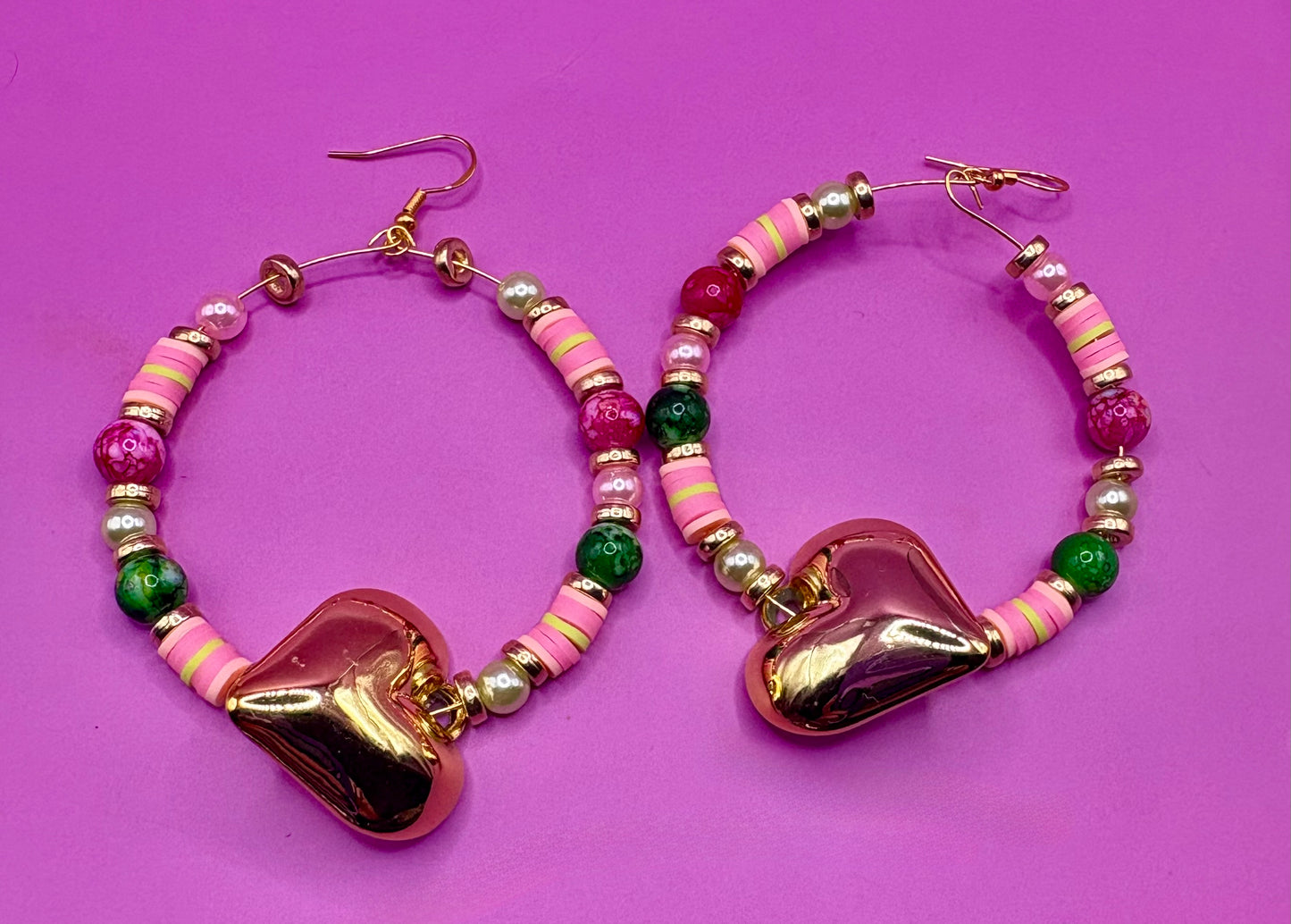 Handmade beaded hoop earrings in pink and green, showcasing vibrant colors and intricate craftsmanship, perfect for adding a playful touch to any outfit and ideal for casual or festive occasions.