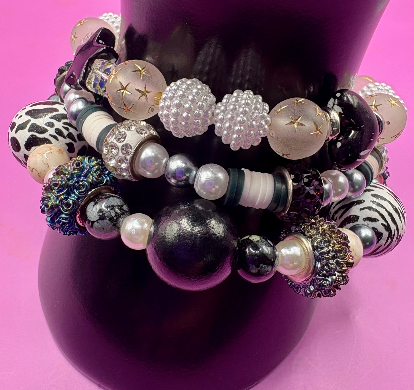Handmade beaded charm bracelets stacked together, showcasing unique designs and vibrant colors, perfect for adding a personalized touch to any jewelry collection. black and white animal zebra cow print star beads