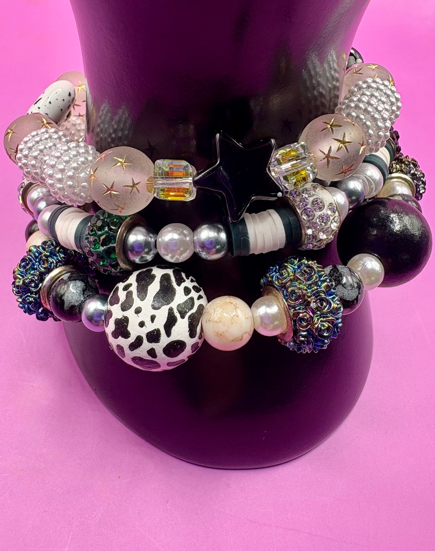 Handmade beaded charm bracelets stacked together, showcasing unique designs and vibrant colors, perfect for adding a personalized touch to any jewelry collection. black and white animal zebra cow print star beads