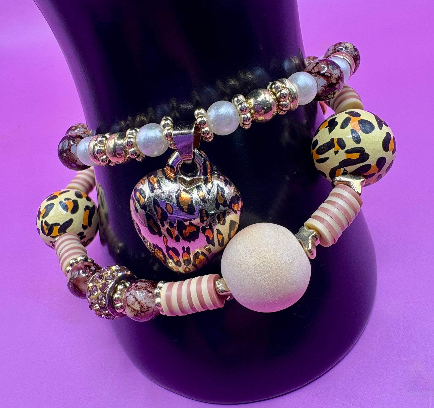 Handmade beaded charm bracelets stacked together, showcasing unique designs and vibrant colors, perfect for adding a personalized touch to any jewelry collection. tan brown leopard print animal print heart pendant