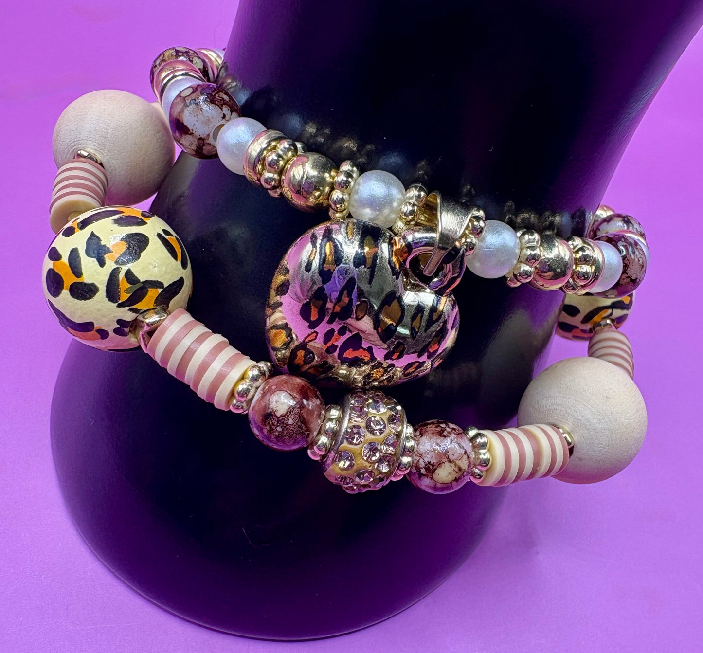 Handmade beaded charm bracelets stacked together, showcasing unique designs and vibrant colors, perfect for adding a personalized touch to any jewelry collection. tan brown leopard print animal print heart pendant