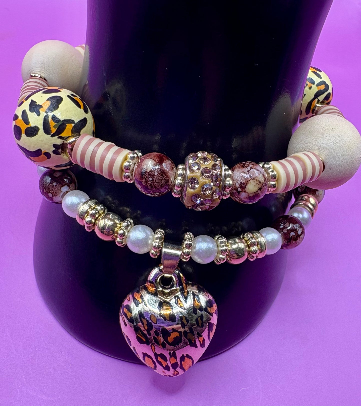 Handmade beaded charm bracelets stacked together, showcasing unique designs and vibrant colors, perfect for adding a personalized touch to any jewelry collection. tan brown leopard print animal print heart pendant