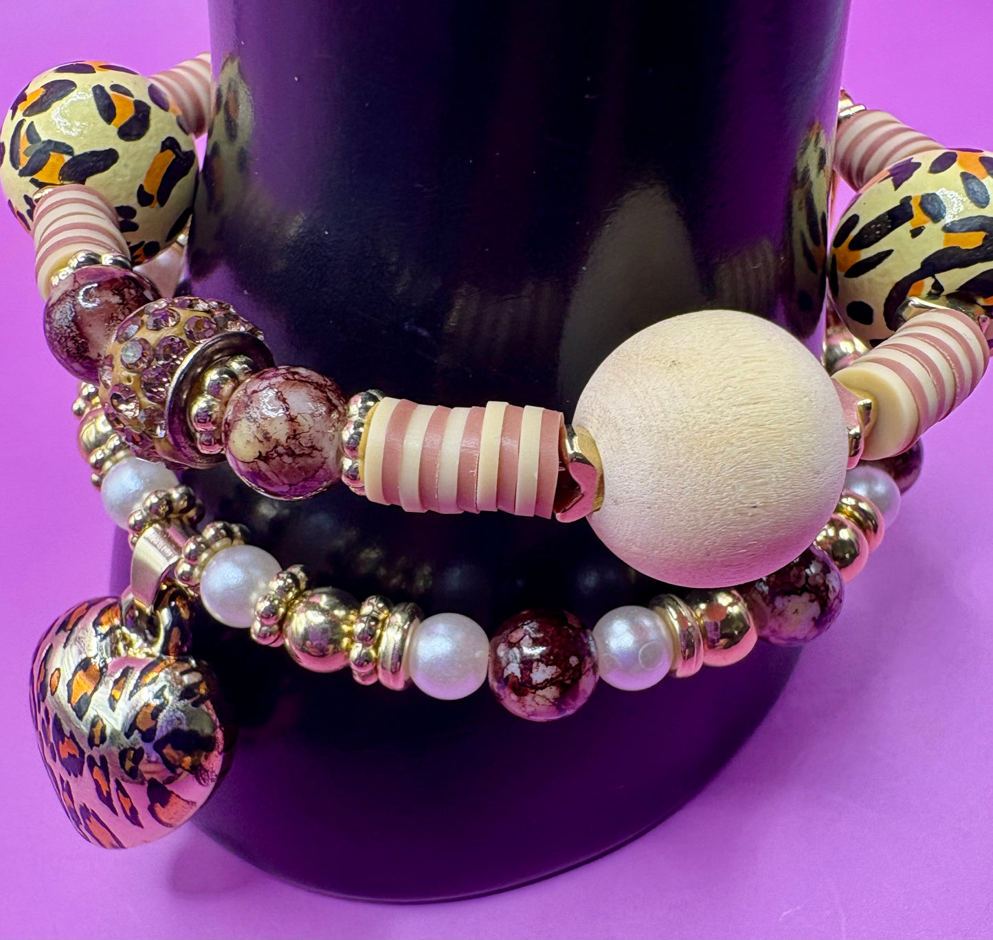 Handmade beaded charm bracelets stacked together, showcasing unique designs and vibrant colors, perfect for adding a personalized touch to any jewelry collection. tan brown leopard print animal print heart pendant