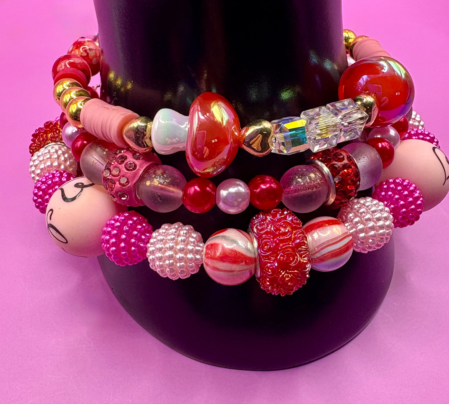 Handmade beaded charm bracelets stacked together, showcasing unique designs and vibrant colors, perfect for adding a personalized touch to any jewelry collection. red toadstool fairy I love you romantic bracelet