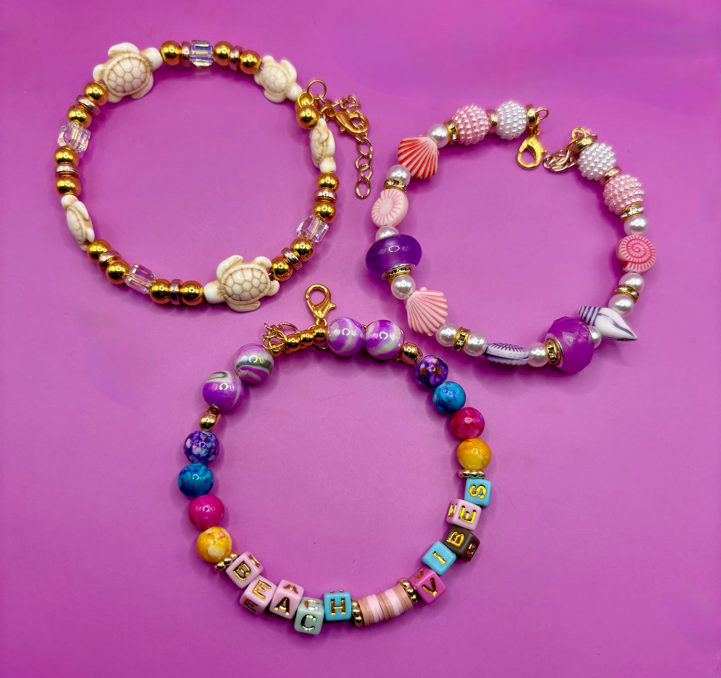 Handmade beaded charm bracelets stacked together, showcasing unique designs and vibrant colors, perfect for adding a personalized touch to any jewelry collection. beach vibes turtles seal life purple