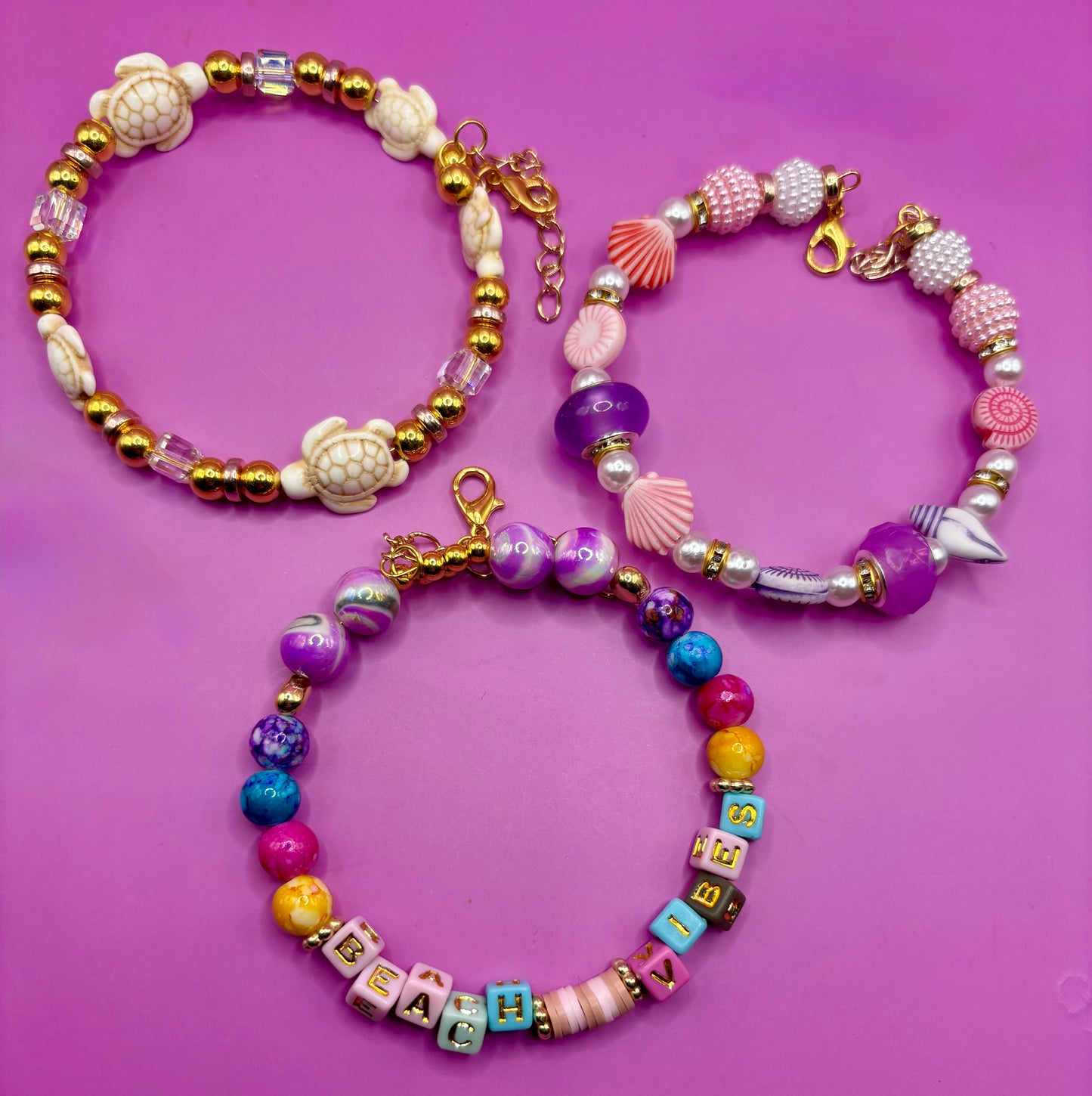 Handmade beaded charm bracelets stacked together, showcasing unique designs and vibrant colors, perfect for adding a personalized touch to any jewelry collection. beach vibes turtles seal life purple