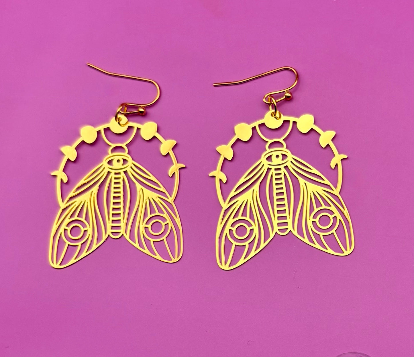 Elegant gold moth dangly earrings, featuring intricate design and lightweight construction, perfect for adding a unique touch to any outfit.