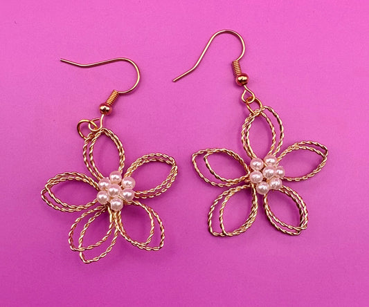 Elegant gold look flower dangly earrings with a pearly center, perfect for adding a touch of sophistication and charm to any outfit.