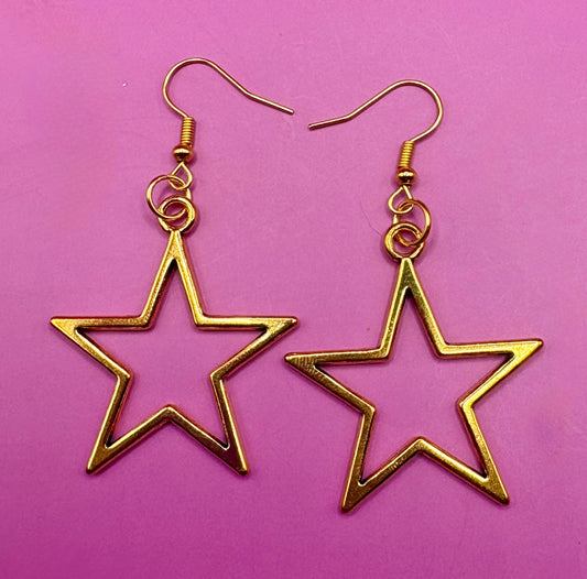Stylish large gold star dangly earrings, featuring a bold and eye-catching design perfect for elevating any outfit with a touch of glamour and shine.