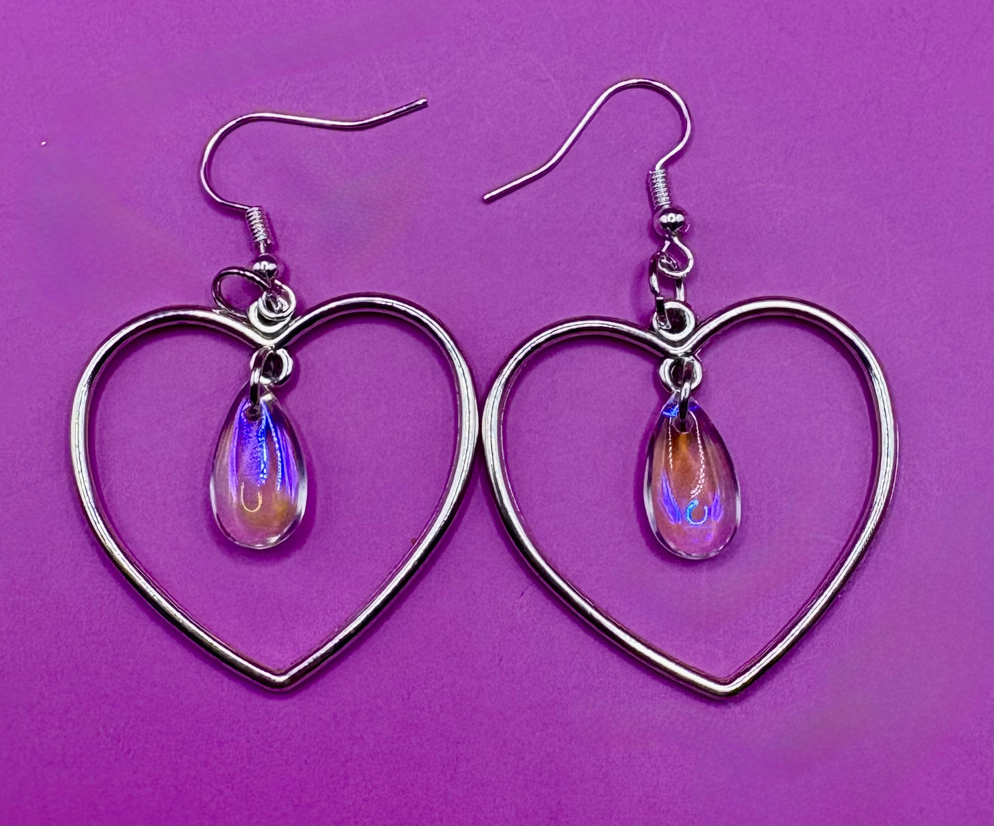 Stylish silver heart hoop dangly earrings, featuring a trendy design perfect for adding a romantic touch to any outfit.
