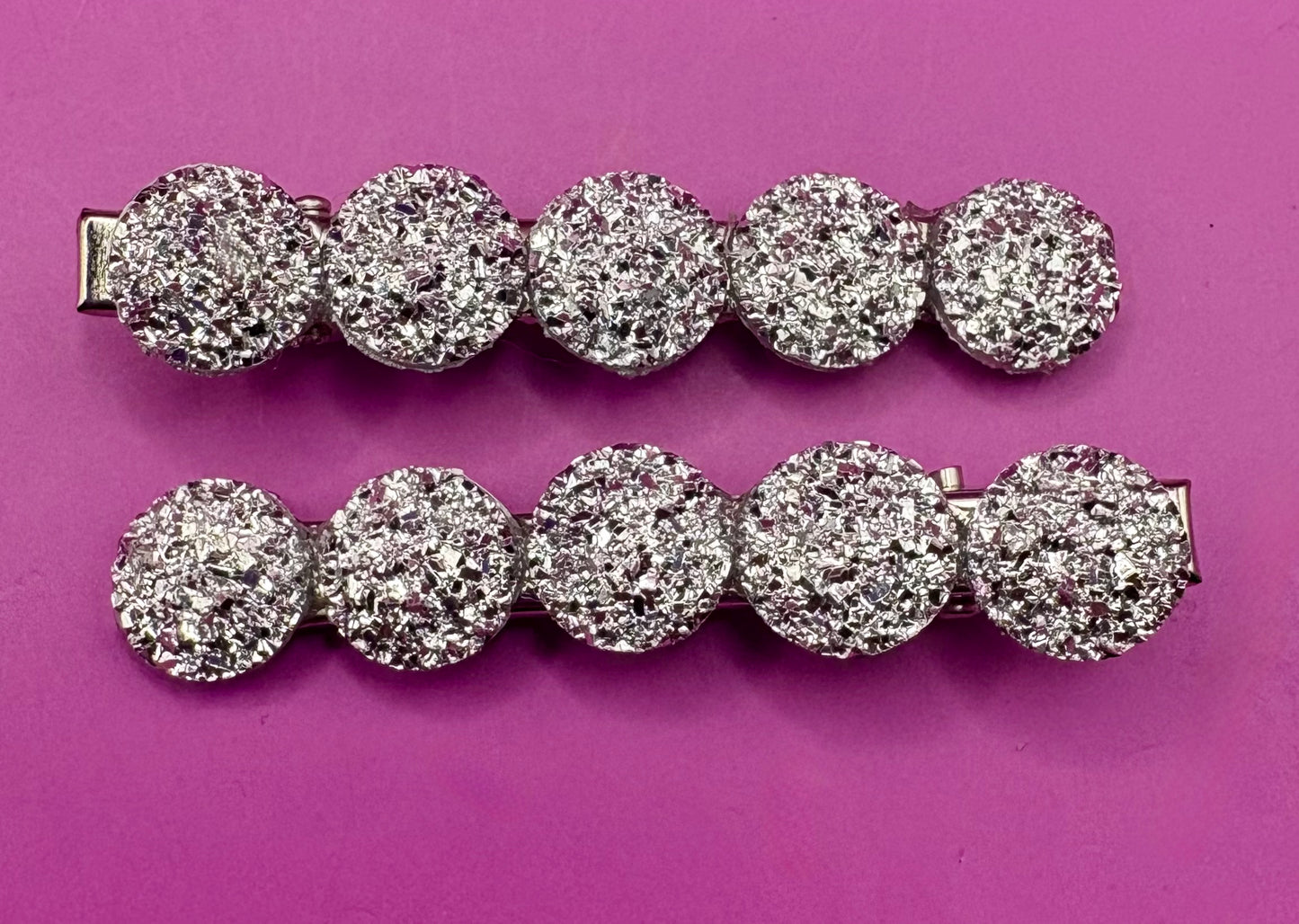 Charming heart-shaped circular glitter hair slides in silver, perfect for festive hairstyles and holiday parties, sold in pairs, each measuring 6cm.