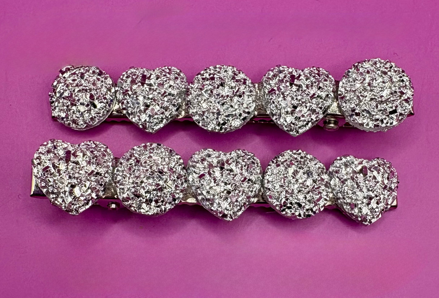 Charming heart-shaped circular glitter hair slides in silver, perfect for festive hairstyles and holiday parties, sold in pairs, each measuring 6cm.