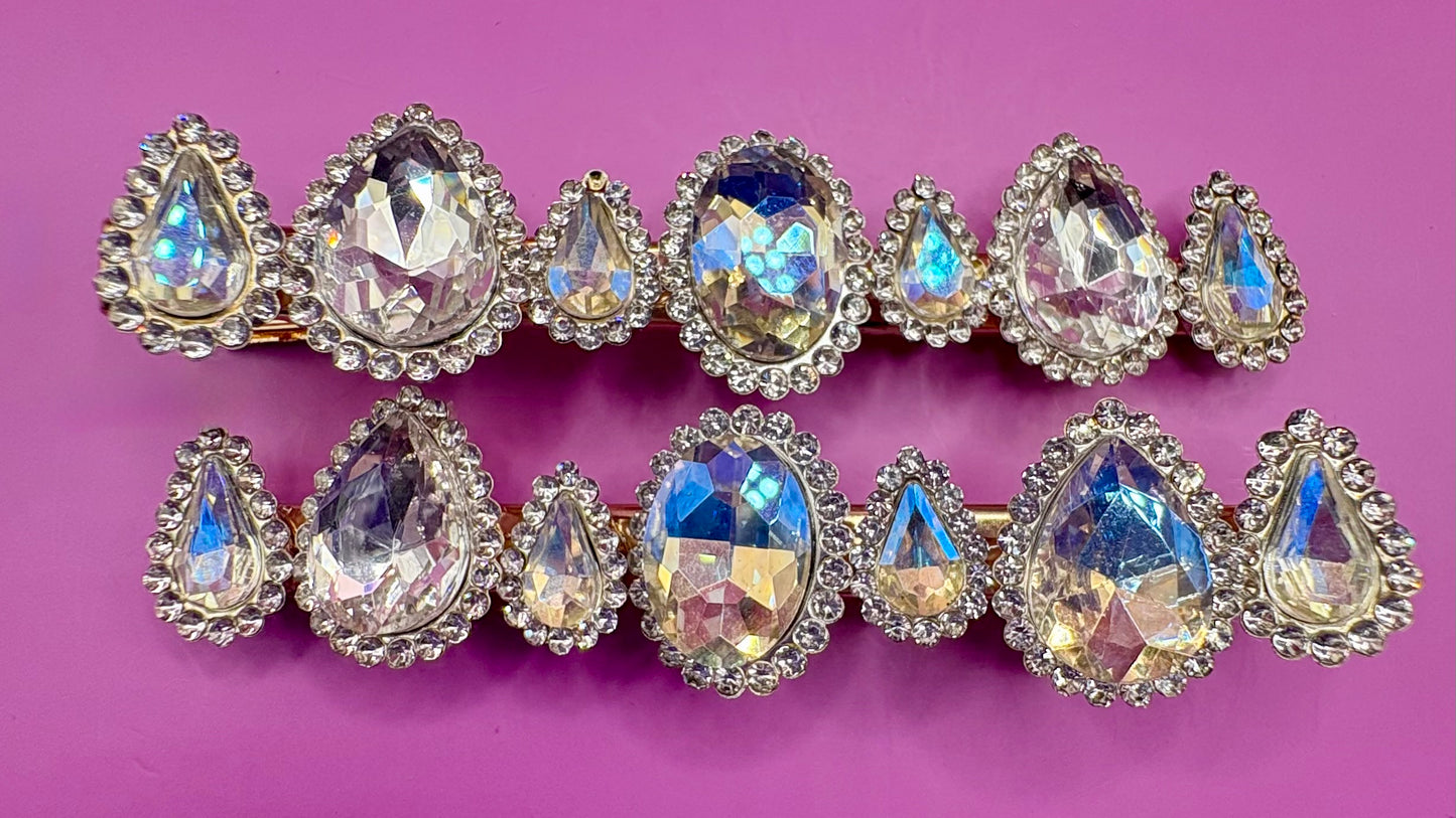 Fashionable silver hair clip featuring unique heart and circular designs embellished with colorful gemstones.
