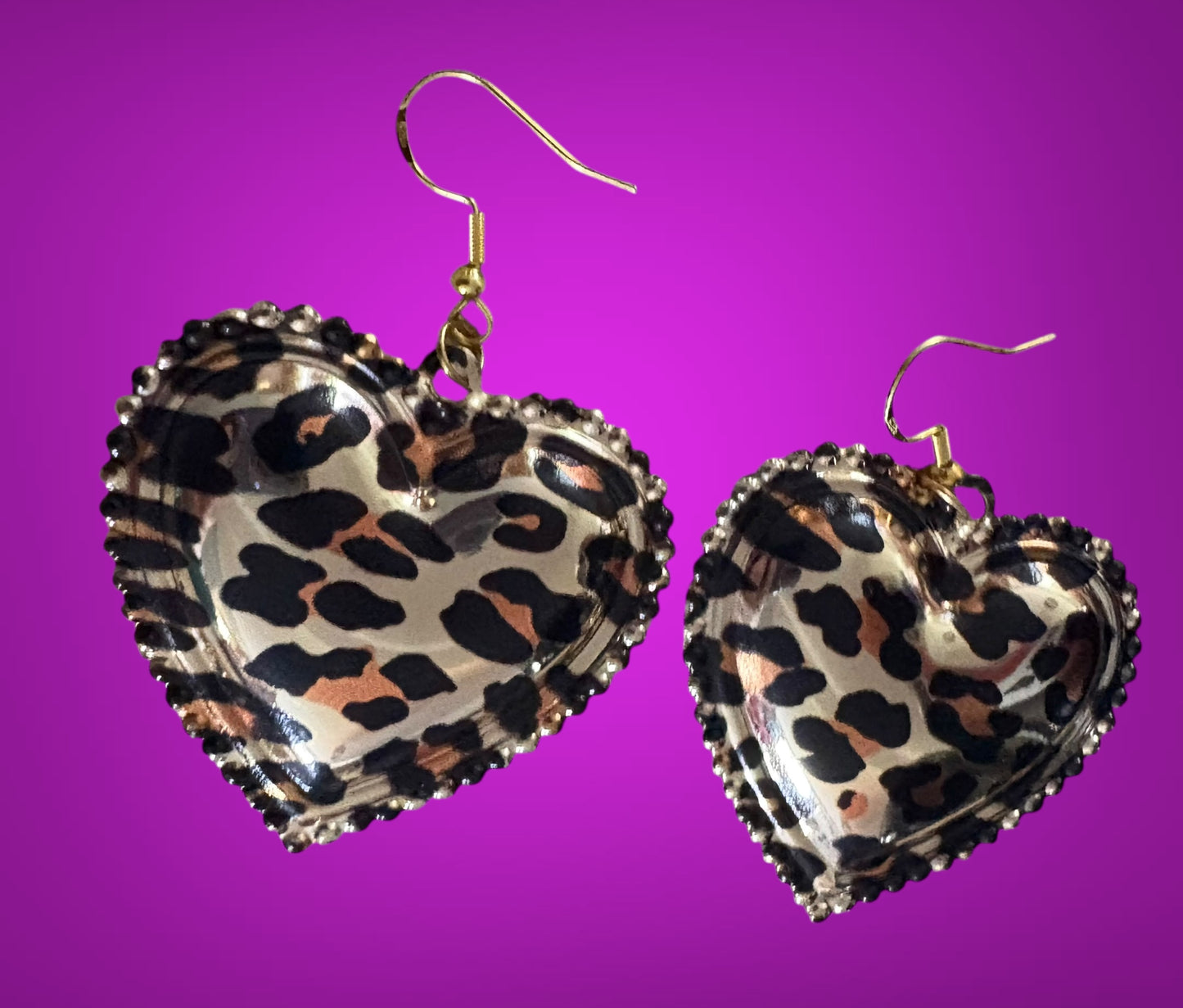 Stylish dangly earrings featuring a heart pendant design in chic leopard print, perfect for adding a touch of wild elegance to your jewelry collection and enhancing any outfit.