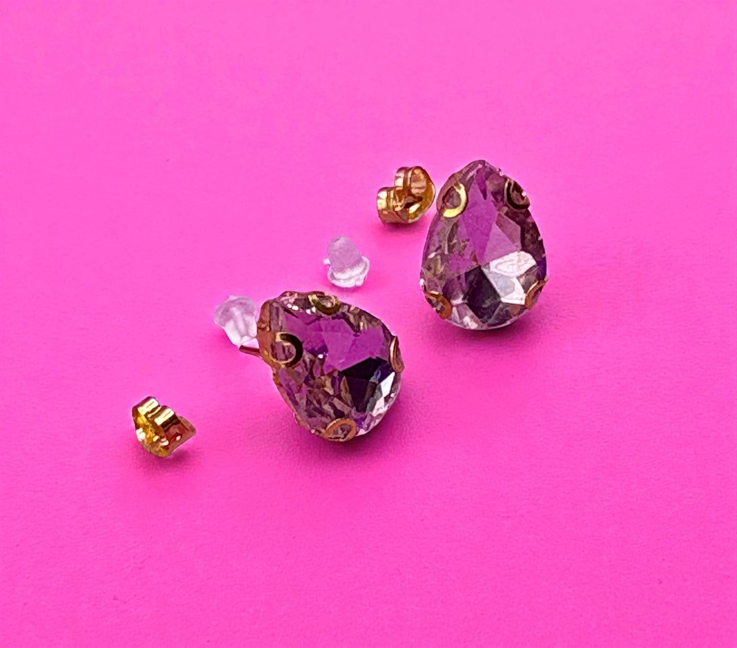 Purple crystal earrings on a pink background
