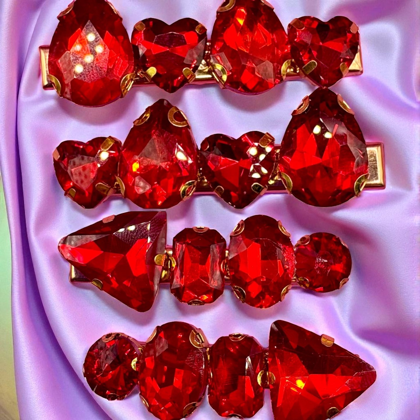 Red gemstone hair clips on a pink fabric background