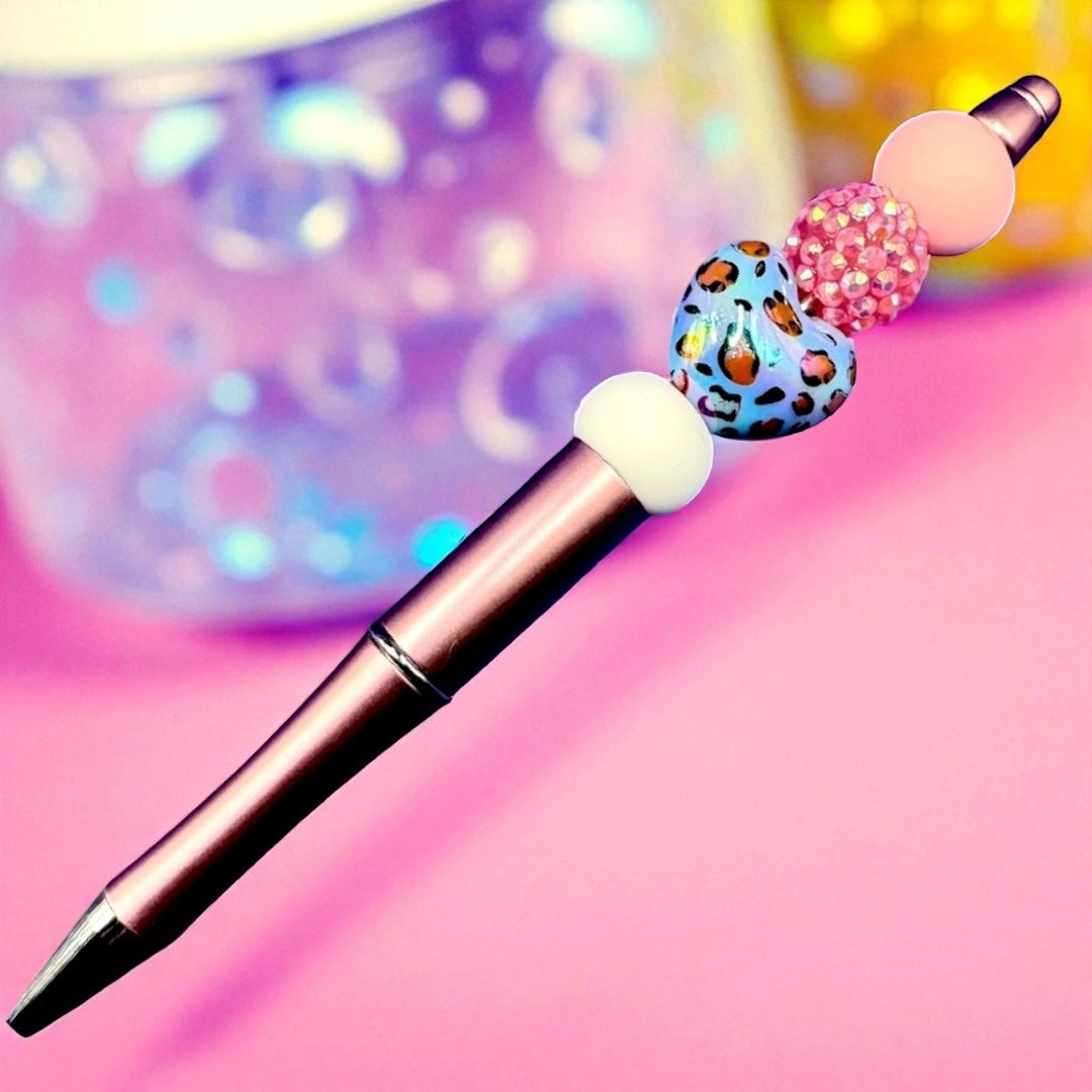 Decorative pen with colorful beads on a pink background