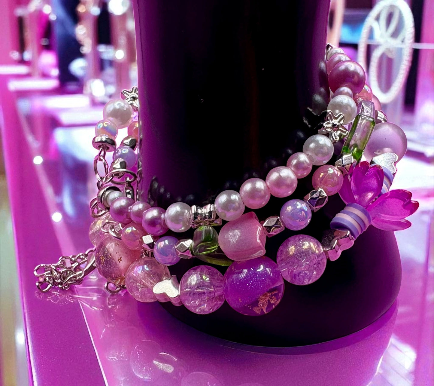 Colorful beaded bracelet on a pink stand with blurred background