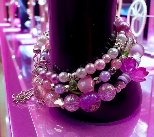 Colorful beaded bracelet on a pink stand with blurred background