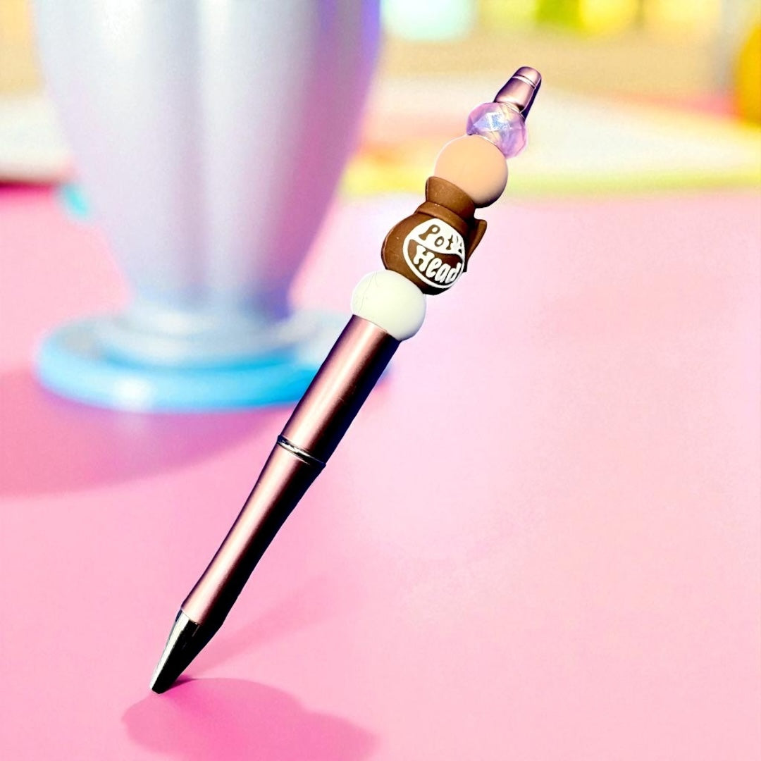 Pen with decorative top on a pink background