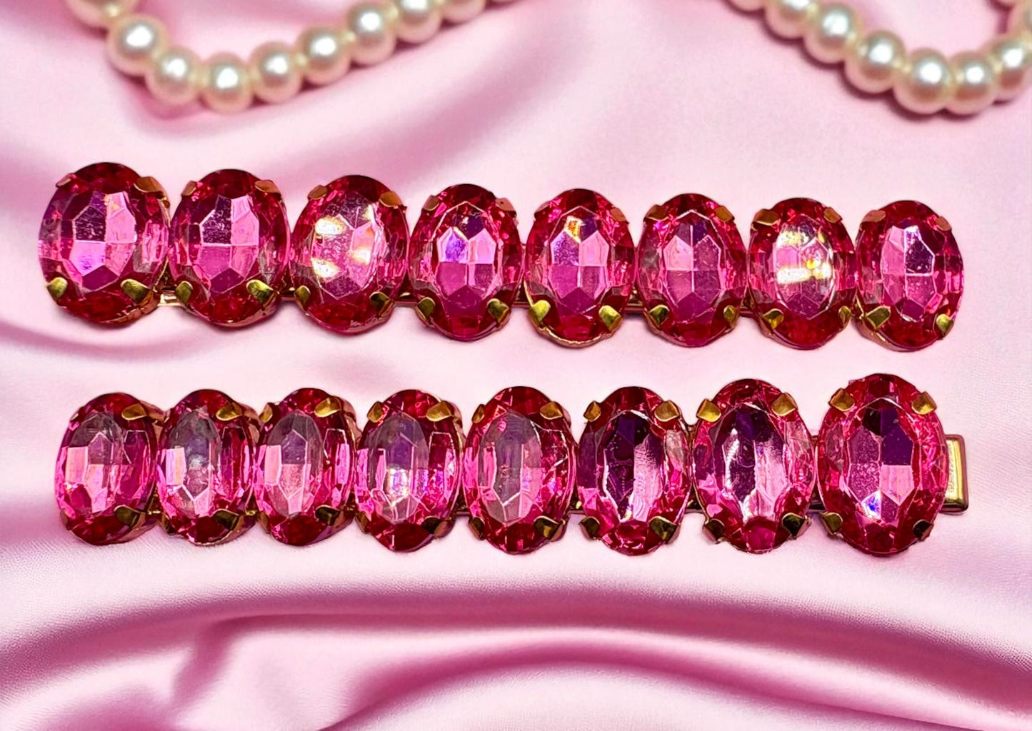 Two pink beaded hair clips on a pink fabric background
