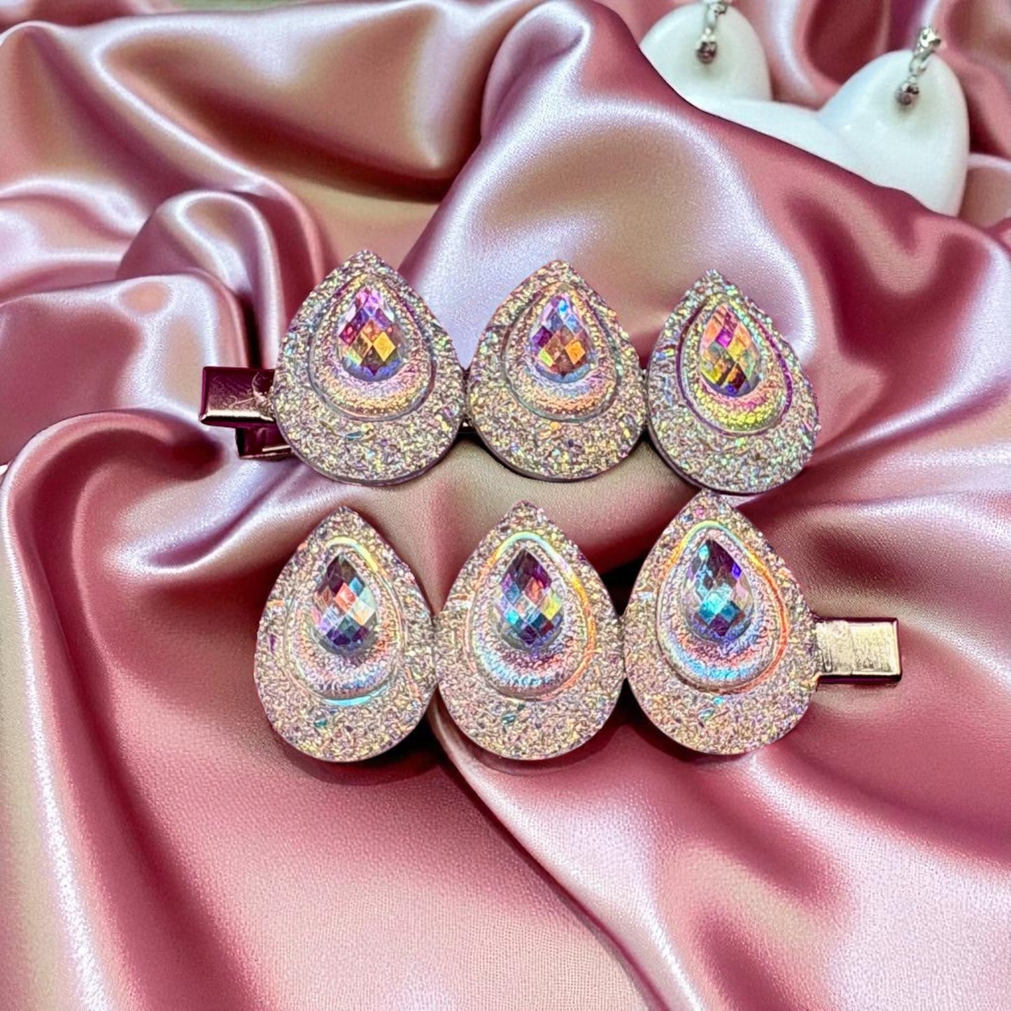 Teardrop-shaped jewelry set on a pink satin background