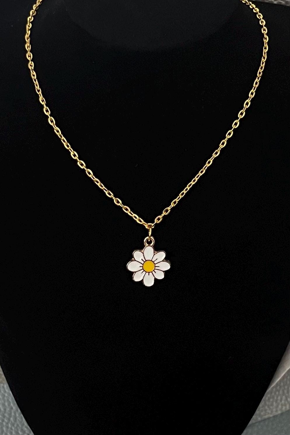 Gold daisy pendant necklace, featuring a charming floral design, perfect for adding a touch of elegance and whimsy to any outfit.