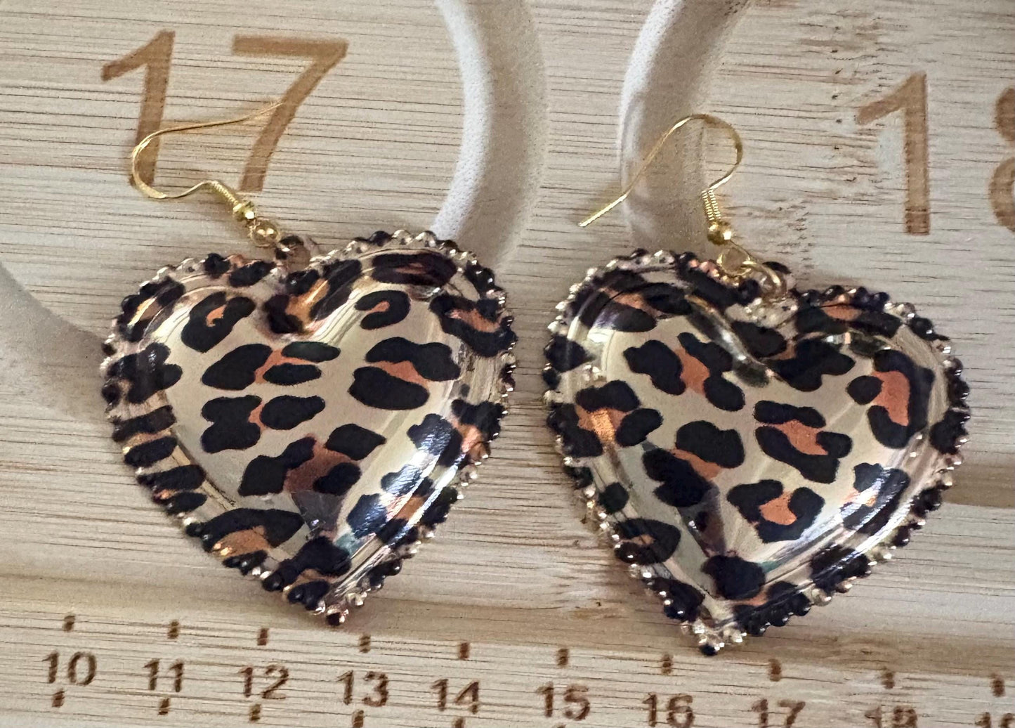 Stylish dangly earrings featuring a heart pendant design in chic leopard print, perfect for adding a touch of wild elegance to your jewelry collection and enhancing any outfit.
