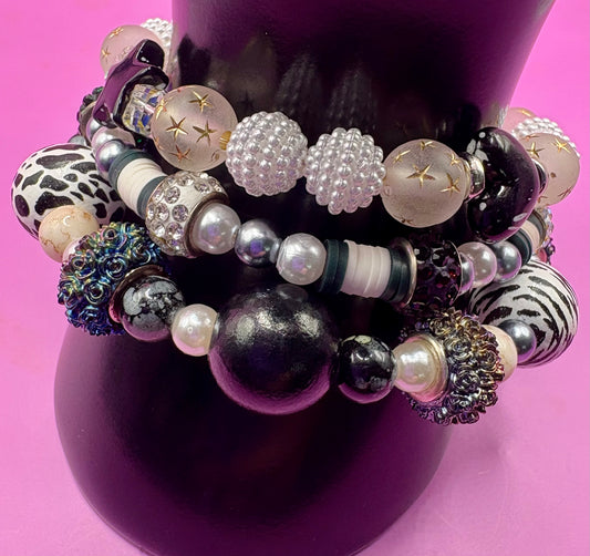 Handmade beaded charm bracelets stacked together, showcasing unique designs and vibrant colors, perfect for adding a personalized touch to any jewelry collection. black and white animal zebra cow print star beads