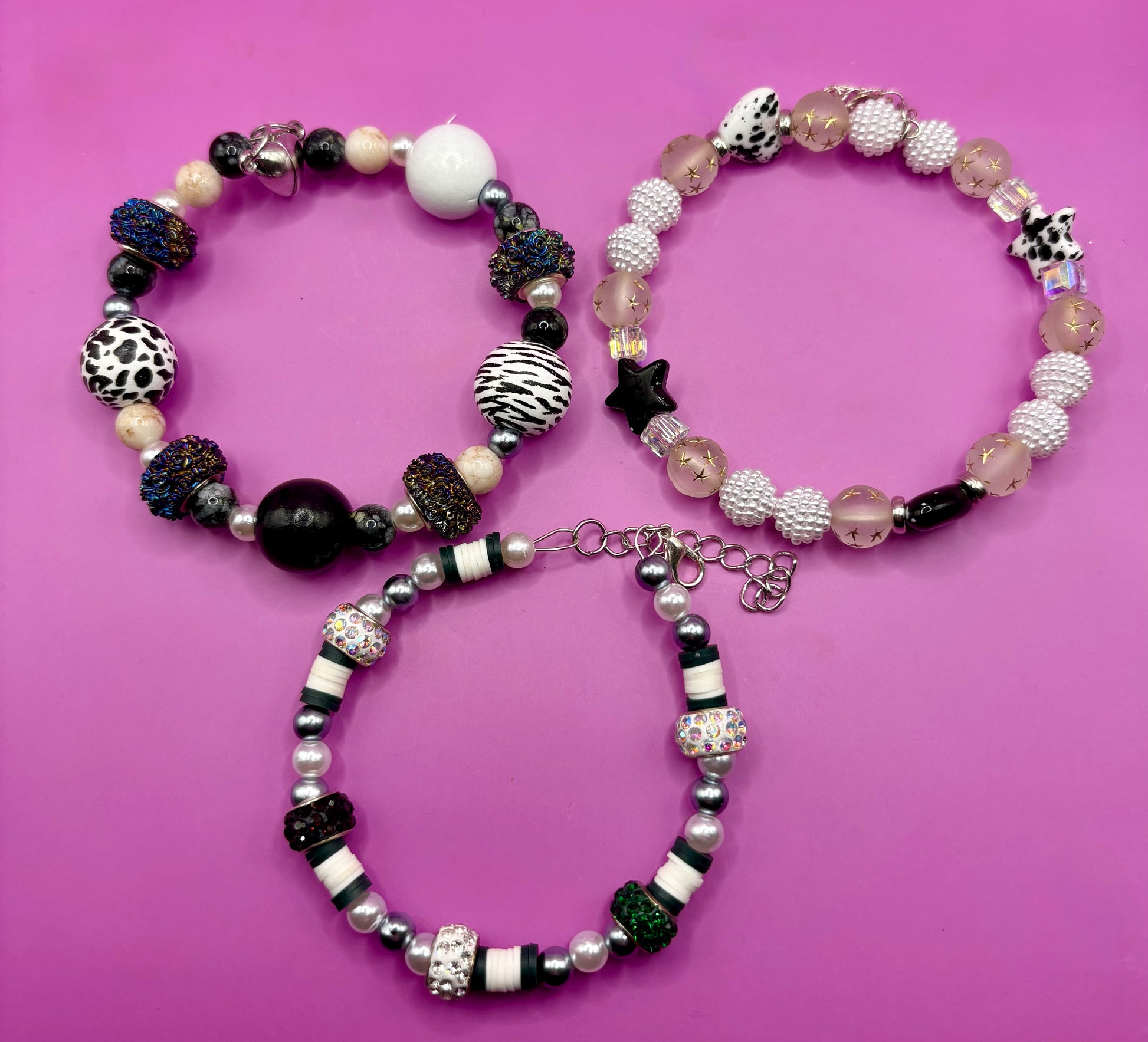 Handmade beaded charm bracelets stacked together, showcasing unique designs and vibrant colors, perfect for adding a personalized touch to any jewelry collection. black and white animal zebra cow print star beads