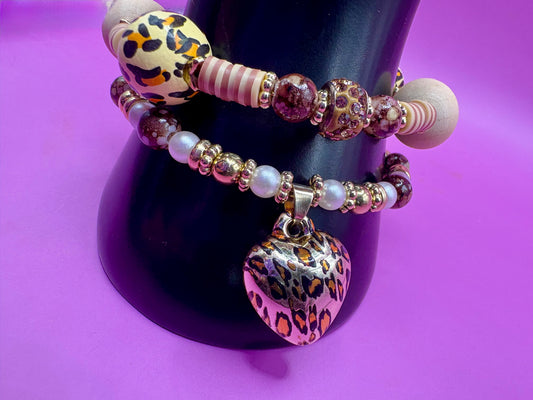 Handmade beaded charm bracelets stacked together, showcasing unique designs and vibrant colors, perfect for adding a personalized touch to any jewelry collection. tan brown leopard print animal print heart pendant