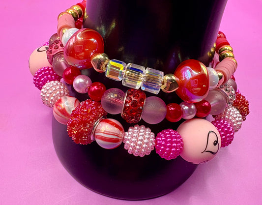 Handmade beaded charm bracelets stacked together, showcasing unique designs and vibrant colors, perfect for adding a personalized touch to any jewelry collection. red toadstool fairy I love you romantic bracelet