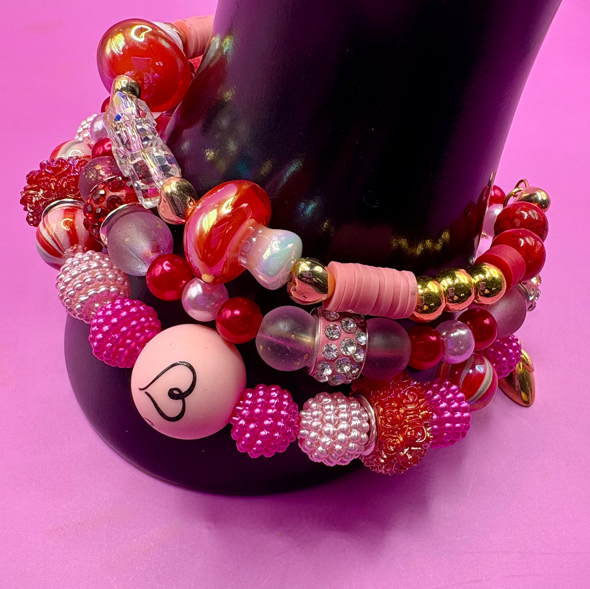 Handmade beaded charm bracelets stacked together, showcasing unique designs and vibrant colors, perfect for adding a personalized touch to any jewelry collection. red toadstool fairy I love you romantic bracelet