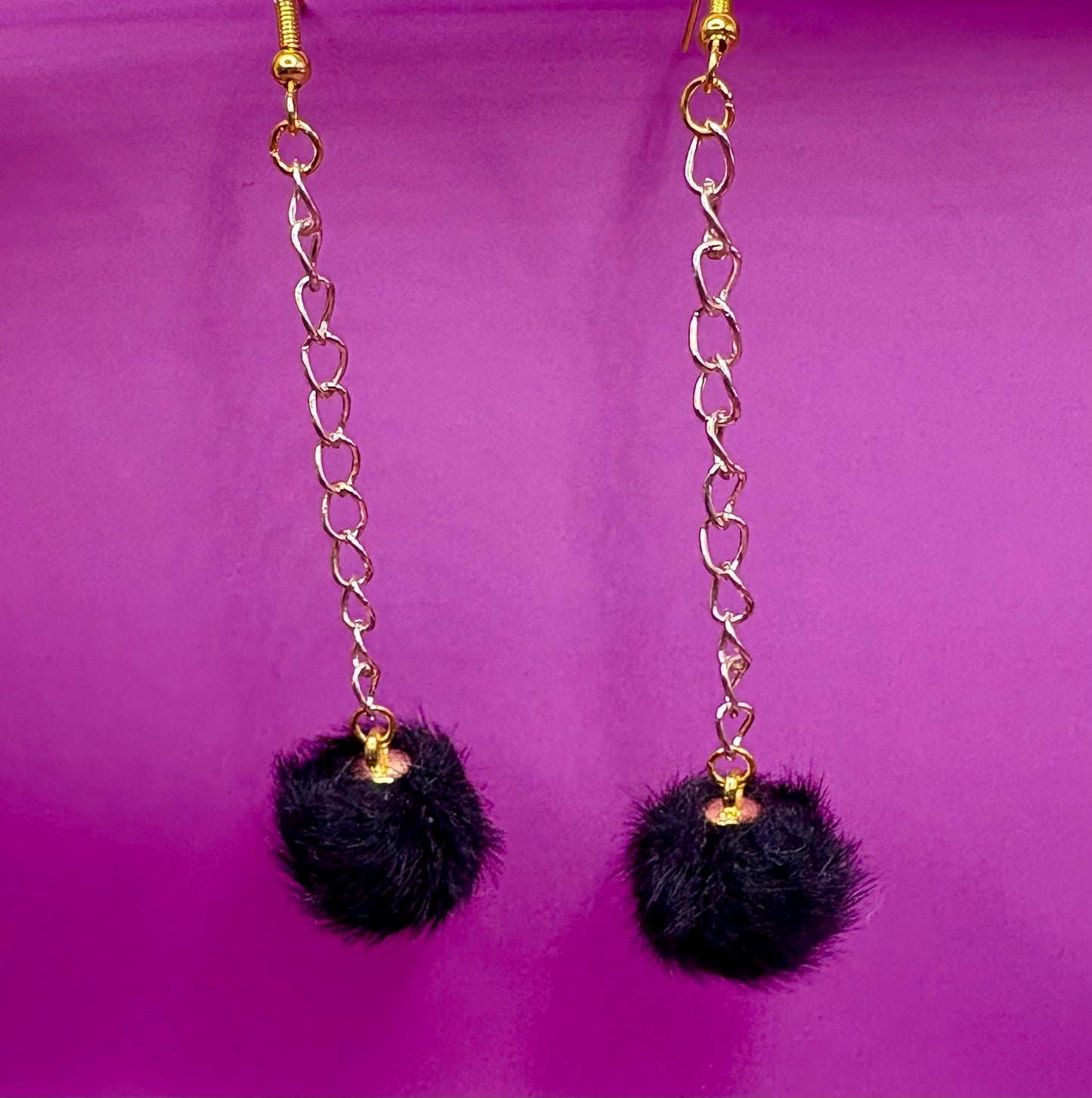 Trendy long dangly drop earrings with fluffy pom pom embellishments, perfect for adding a playful and stylish touch to your accessory collection for any occasion.