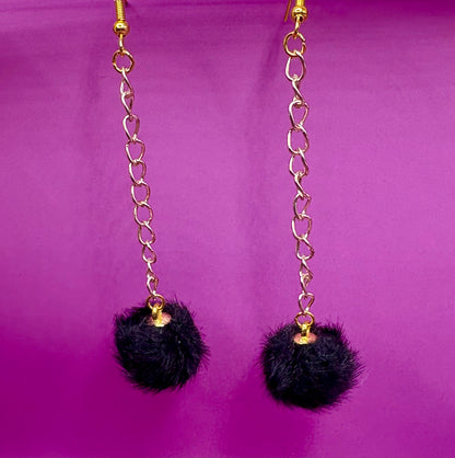 Trendy long dangly drop earrings with fluffy pom pom embellishments, perfect for adding a playful and stylish touch to your accessory collection for any occasion.