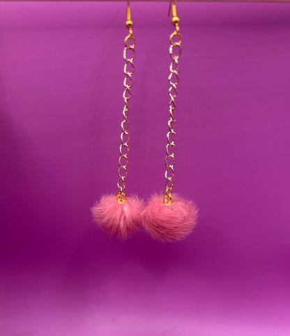 Trendy long dangly drop earrings with fluffy pom pom embellishments, perfect for adding a playful and stylish touch to your accessory collection for any occasion.