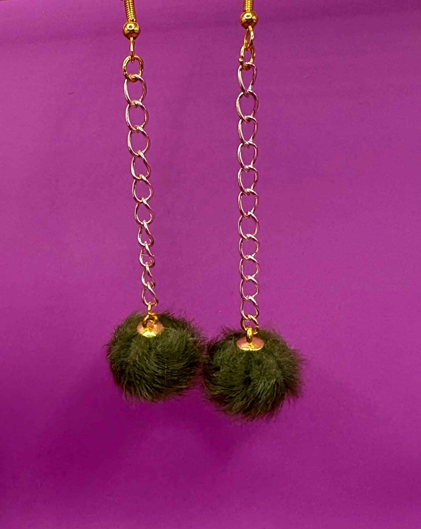 Trendy long dangly drop earrings with fluffy pom pom embellishments, perfect for adding a playful and stylish touch to your accessory collection for any occasion.