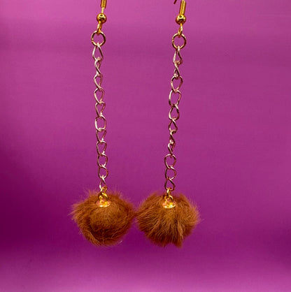 Trendy long dangly drop earrings with fluffy pom pom embellishments, perfect for adding a playful and stylish touch to your accessory collection for any occasion.
