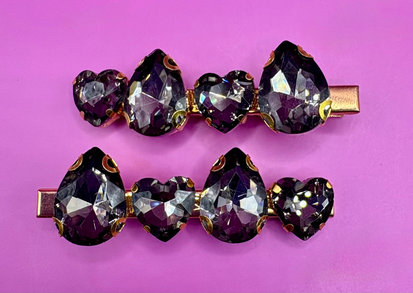 Elegant pair of pink and purple gemstone hair slides, ideal for enhancing your hairstyle with a touch of glamour and color.