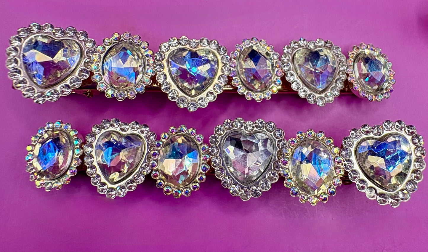 Fashionable silver hair clip featuring unique heart and circular designs embellished with colorful gemstones.