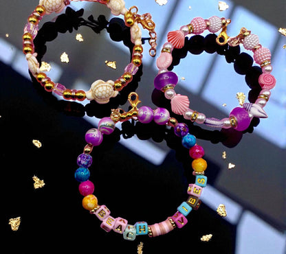 Colorful beaded bracelets on a reflective surface with a blurred background
