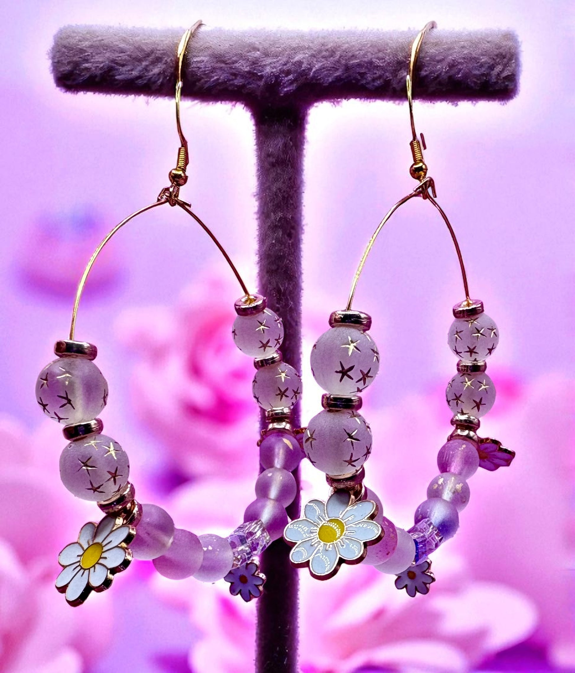 Hoop earrings with floral beads on a purple background