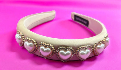 Decorative headband with heart-shaped pearls on a pink background