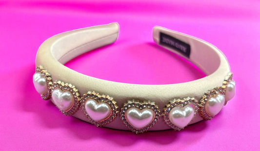 Decorative headband with heart-shaped pearls on a pink background