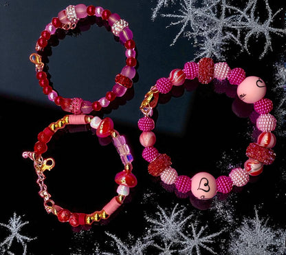 Two beaded bracelets on a black background with decorative snowflake elements.