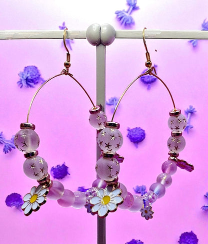 Hoop earrings with floral beads on a pink background