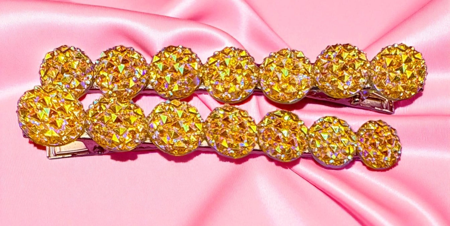 Gold hair clip with large round crystals on a pink satin background