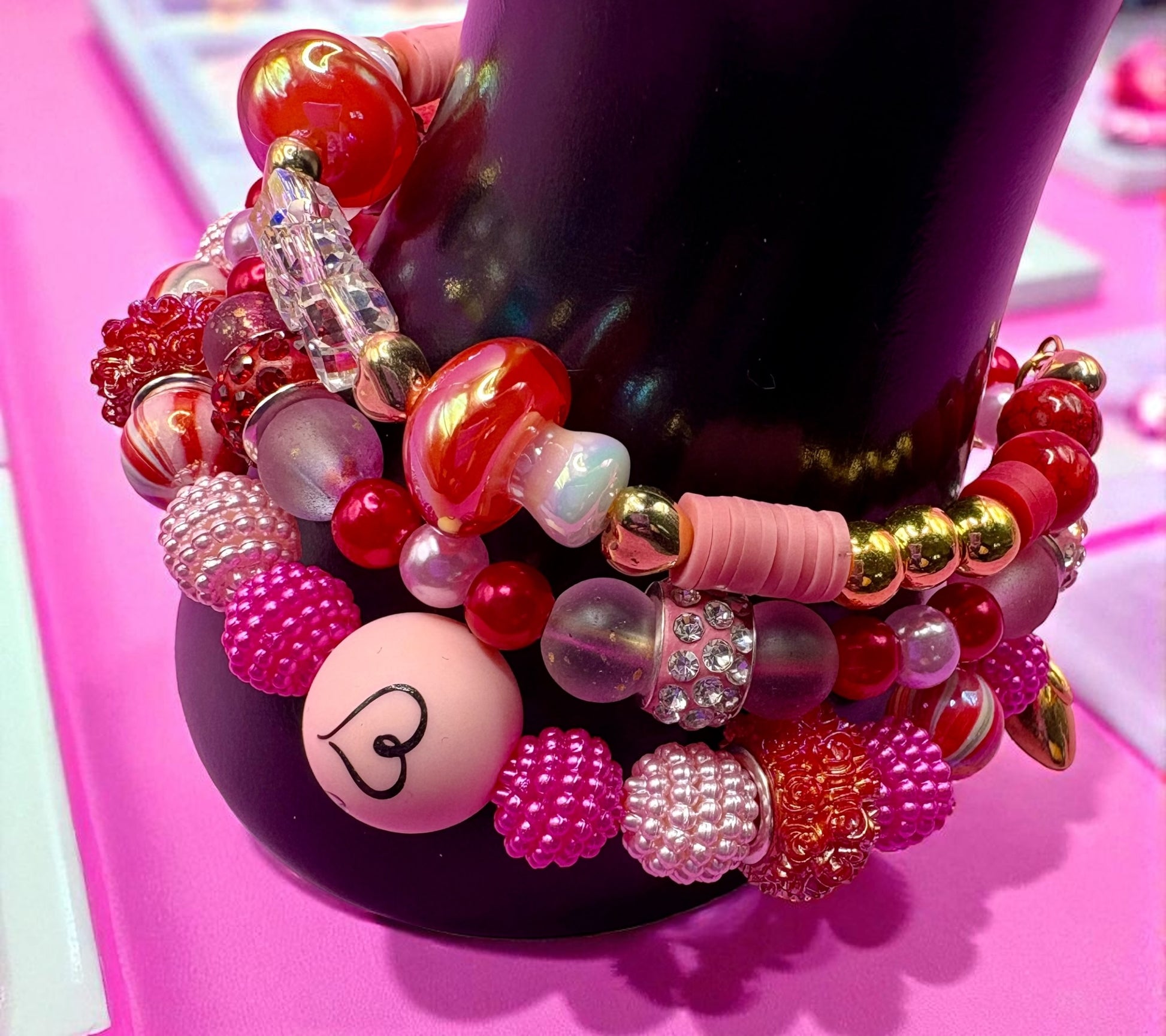 Colorful beaded bracelet with various beads on a pink surface