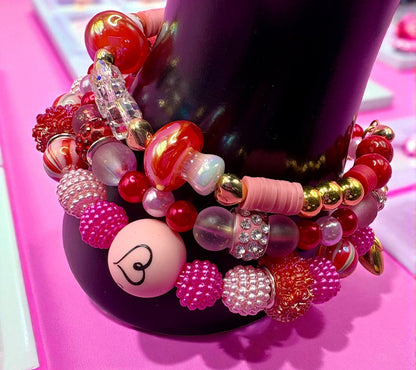 Colorful beaded bracelet with various beads on a pink surface